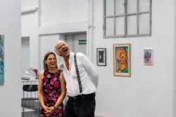 Vernissage Künstlerin Andrea Simon Thema Spuren Kunsthalle Frankfurt Juli 2024 Zwei lachende Personen in einer Kunstgalerie mit Gemälden an den Wänden