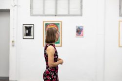 Vernissage Künstlerin Andrea Simon Thema Spuren Kunsthalle Frankfurt Juli 2024 Frau betrachtet Kunstwerke in einer minimalistischen Galerie