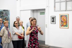 Vernissage Künstlerin Andrea Simon Thema Spuren Kunsthalle Frankfurt Juli 2024 Frau hält Vortrag in einer modernen Kunstgalerie mit aufmerksamen Zuhörern