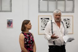 Vernissage Künstlerin Andrea Simon Thema Spuren Kunsthalle Frankfurt Juli 2024 Älterer Mann mit Aufhängeträgern spricht neben einer Frau in einer Galerie