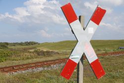 Insel Wangerooge Landschaftsfotografie Mai 2020 Eisenbahnkreuzung vor einer grünen Landschaft mit Wolken am Himmel