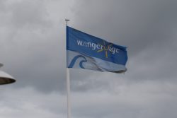 Insel Wangerooge Landschaftsfotografie Mai 2020 Flagge mit Schriftzug Wangerland vor bewölktem Himmel