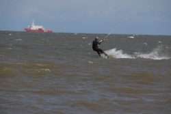 Insel Wangerooge Landschaftsfotografie Mai 2020 Kitesurfer in der Nordsee mit vorbeifahrendem Schiff im Hintergrund