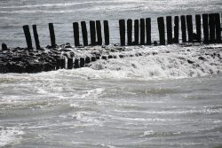 Insel Wangerooge Landschaftsfotografie Mai 2020 Holzpfähle am rauen Meerufer an einem stürmischen Tag