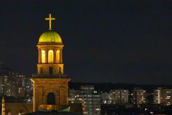 Weihnachtliches Frankfurt Dezember 2024 Beleuchteter Kirchturm mit goldenem Kreuz bei Nacht in einer Stadt