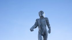 Zugspitze Dezember 2022 Vereiste Holzskulptur eines stehenden Menschen vor klarem Himmel