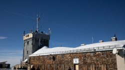Zugspitze Dezember 2022 Schneebedecktes Gebäude und Stahlturm gegen blauen Himmel