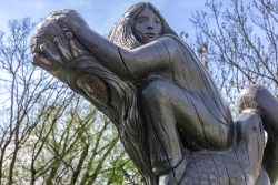 Frühling Bad Vilbel Ostern 2026 Holzskulptur eines sitzenden Mädchens auf einem Tier vor kahlen Bäumen