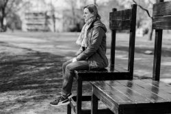 Frühling Bad Vilbel Ostern 2026 Frau sitzt auf überdimensioniertem Stuhl im Freien, schwarz-weiß Fotografie