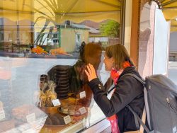 Meissen Mai 2026 Frau betrachtet eine Bäckerei-Vitrine mit Kuchen und Gebäck