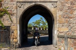 Meissen Mai 2026 Motorradfahrer passiert mittelalterliches Stadttor unter strahlendem Himmel