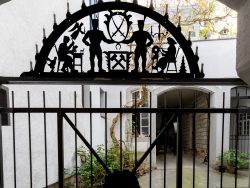 Meissen Mai 2026 Eisentor mit Scherenschnitt von Handwerkern und Vögeln in Innenhof