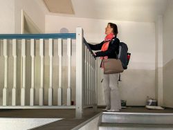 Meissen Mai 2026 Frau mit Rucksack in einem Treppenhaus steht an einem Geländer