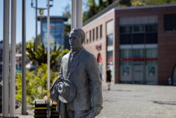 Meissen Mai 2026 Statue eines Mannes mit Hut vor einem modernen Gebäude