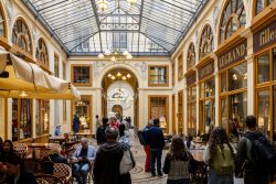 Paris Juni 2026 Geschäftiger überdachter Einkaufsbereich mit Menschen in einer historischen Passage