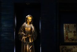 Paris Juni 2026 Mittelalterliche Holzskulptur einer Heiligenfigur im Museum mit beleuchtetem Hintergrund