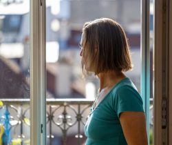 Paris Juni 2026 Frau schaut aus dem Fenster bei Tageslicht