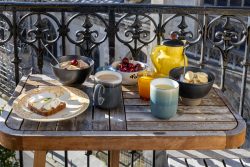 Paris Juni 2026 Frühstück auf einem Balkon mit Müsli, Kaffee, Tee und Obst