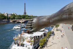 Paris Juni 2026 Nahaufnahme eines Bronzefußes mit Eiffelturm und Seine im Hintergrund