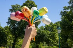 Paris Juni 2026 Bunte, übergroße Tulpenblumen in einem Park, die in einer Hand gehalten werden