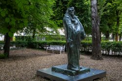 Paris Juni 2026 Bronzestatue in einem grünen Park mit Bäumen und Bank