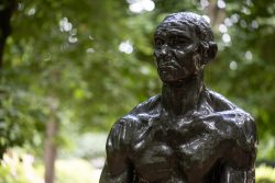 Paris Juni 2026 Bronzestatue eines muskulösen Mannes im Park mit grüner Umgebung