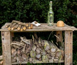 Die Kirschen in Nachbars Garten Holztisch im Garten mit Flaschen und Brennholz