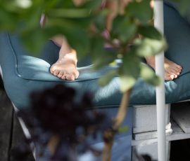 Die Kirschen in Nachbars Garten Barfuß auf blauer Gartenliege im Sommer mit Pflanzen im Vordergrund