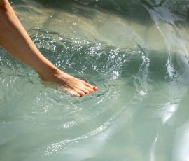 Die Kirschen in Nachbars Garten Benutzerin testet Badewassertemperatur mit Zehen im hellen Pool