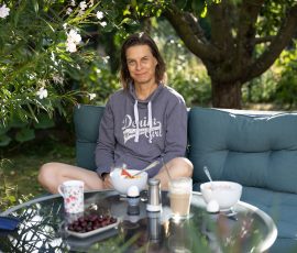 Die Kirschen in Nachbars Garten Frau entspannt auf einem Gartensofa mit Frühstück im Freien