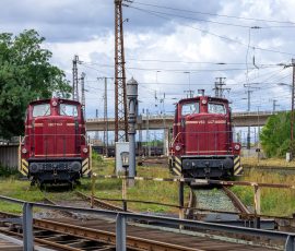 Museumseisenbahn Hanau e. V. Bahnbetriebswerk, Heideäcker 1, 63457 Hanau Fotos von Aloys Peter Trenz Zwei rote Diesellokomotiven auf einem Schienenbahnhof unter bewölktem Himmel
